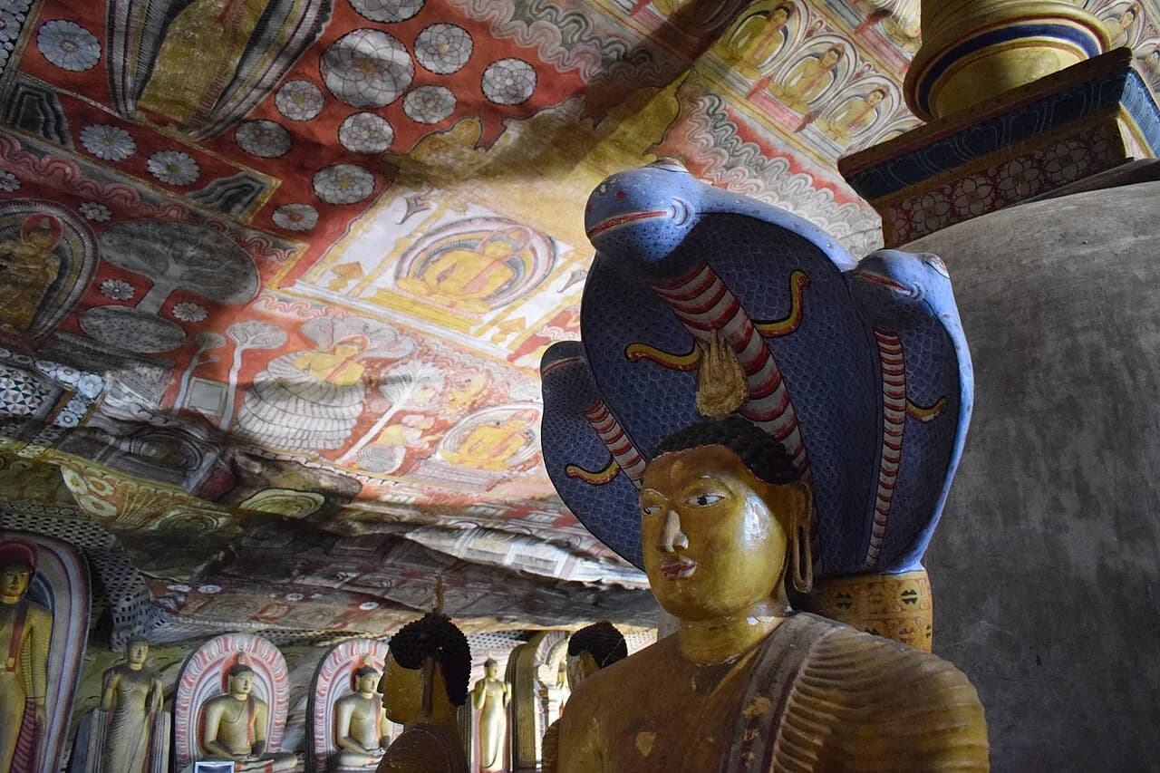 Dambulla - Buddha statue with blue cobra in the caves at Golden Temple in Dambulla.JPG